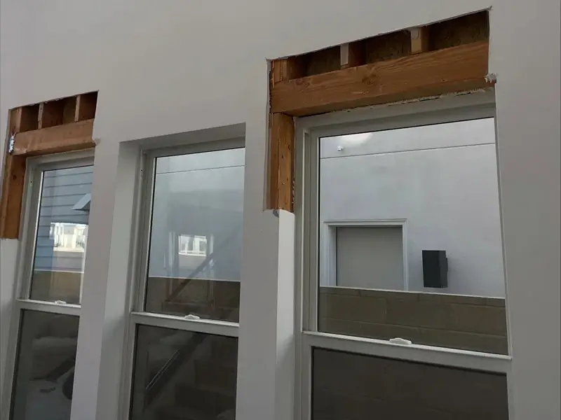 Partially demolished wall with three windows.