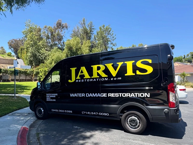 Black Jarvis Restoration van parked on a suburban street.